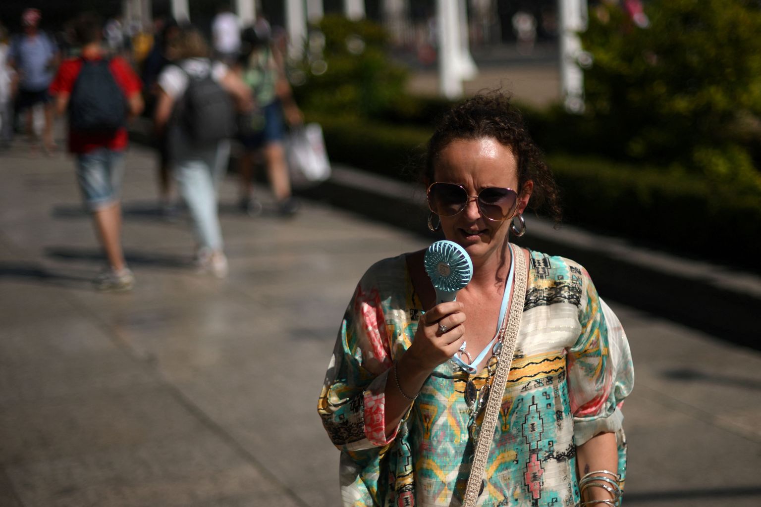 Женщина с ручным вентилятором в центре Лондона. Из-за жары в Великобритании в субботу, 16 июля, был созван национальный кризисный штаб.