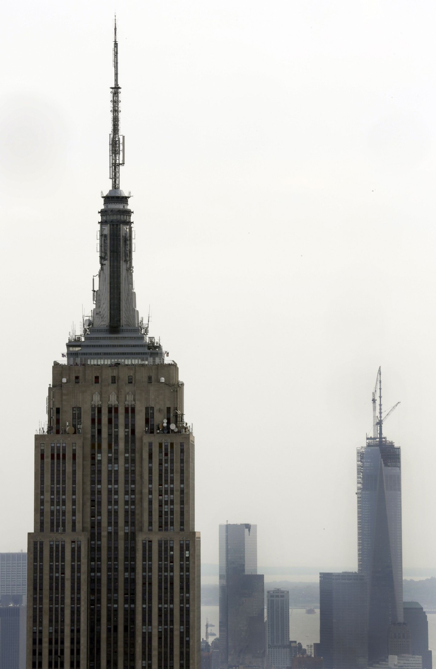 The 1,454-foot Empire State Building, left, and the 1,776-foot One World Trade Center, right, are shown in this photo from New York"s Top of the Rock Observation Deck at Rockefeller Center,  Friday, May 10, 2013. A tall, heavy spire was fully installed atop One World Trade Center on Friday, bringing the New York City structure to its symbolic height of 1,776 feet. The installation makes One World Trade Center the tallest skyscraper in the U.S. and third-tallest in the world, although building experts dispute whether the spire is actually an antenna Ñ a crucial distinction in measuring the building's height. (AP Photo/Richard Drew) / SCANPIX Code: 436