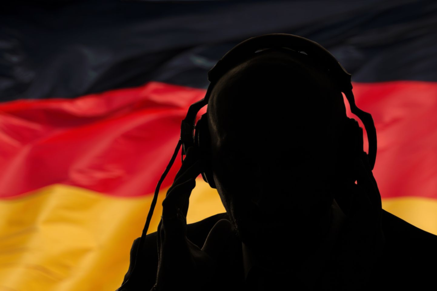Человек в наушниках на фоне флага Германии