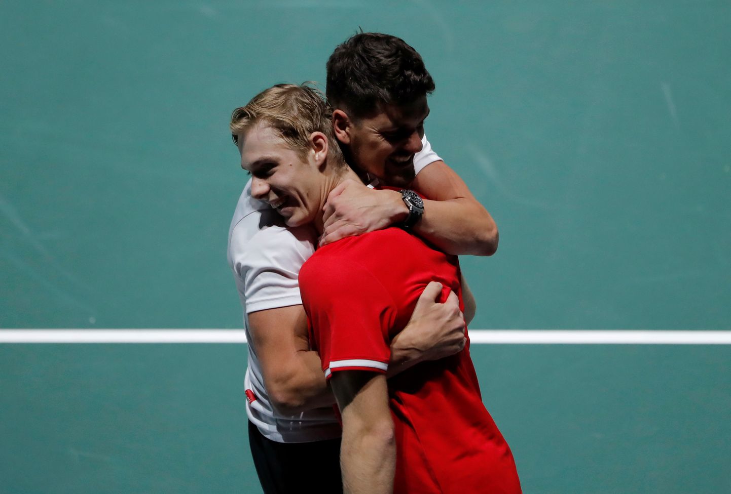 Davis Cup finaalturniiril Madridis võtab Kanada tennisist Denis Shapovalov (punases) pärast Matteo Berrettini alistamist vastu õnnitlusi meeskonna kaptenilt Frank Dancevicilt.