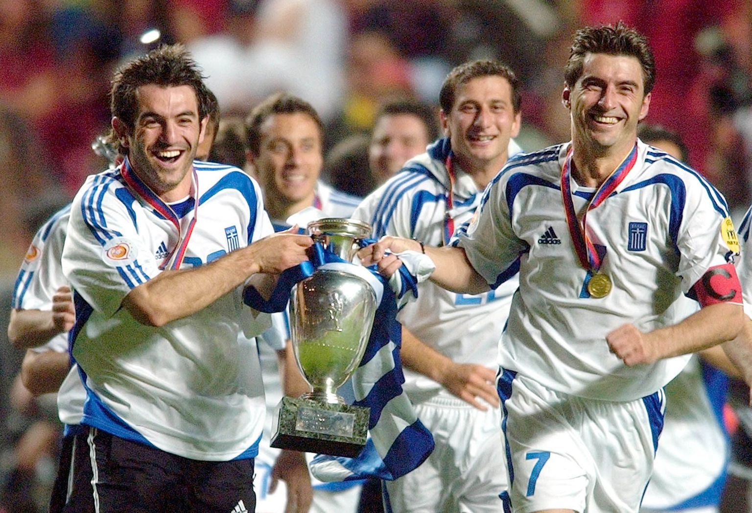 Kreeka koondislased Georgios Karagounis (vasakul) ja Theodoros Zagorakis 2004. aasta EM-finaali järel Euroopa meistrikarikaga võitu tähistamas. Finaalis alistati 1:0 Portugal.
