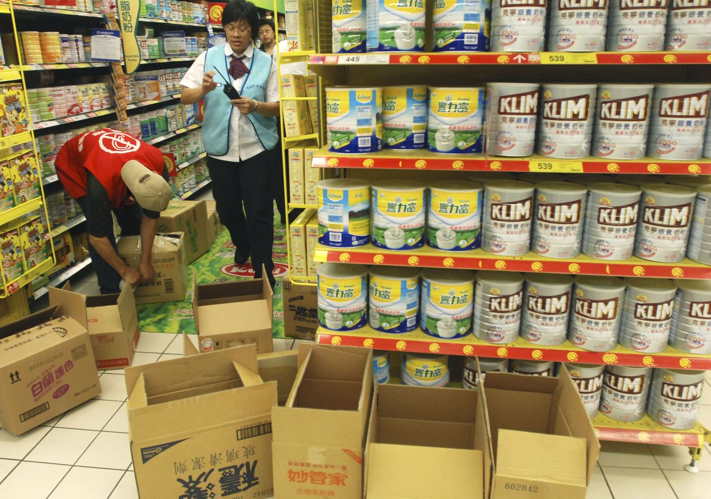Taipei toidupoe töötajad kõrvaldavad riiulitelt Hiina piimapulbrit sisaldavaid tooteid.