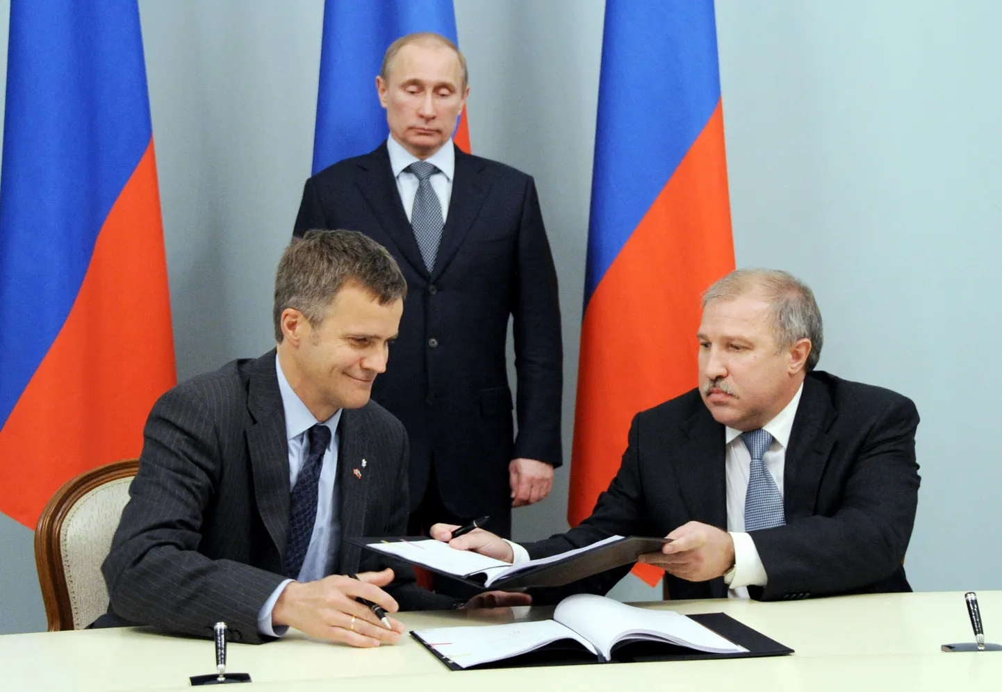 Venemaa peaminister ja uueks presidendiks valitud Vladimir Putin jälgib, kuidas Norra Statoili juhatuse esimees Helge Lund (vasakul) ja Rosnefti president Eduard Hudainatov koostööleppe allkirjastamisstseremoonial dokumente vahetavad.