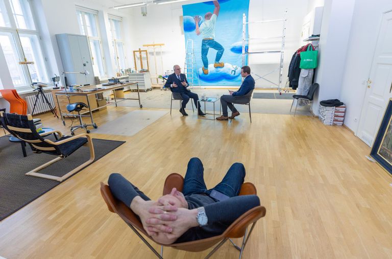 Художник Кайдо Оле внимательно слушает интервью, которое проводится в его мастерской в Пыхья-Таллинне. На заднем плане – незавершенная картина «„К“ и „О“ отправляются на небеса».