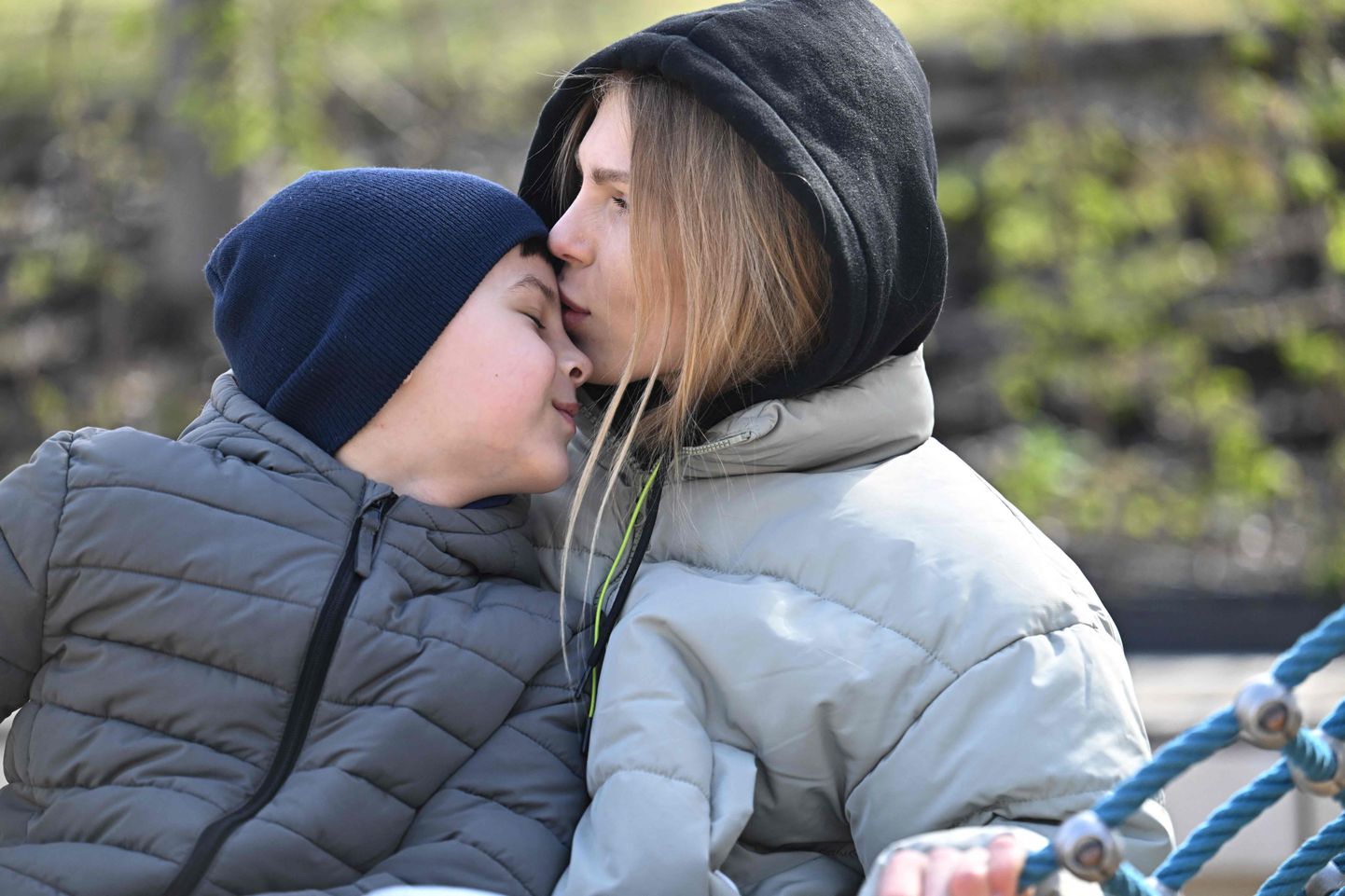 Украинская мама Ирина Брык со своим страдающим аутизмом сыном Романом на детской площадке в Венгрии.