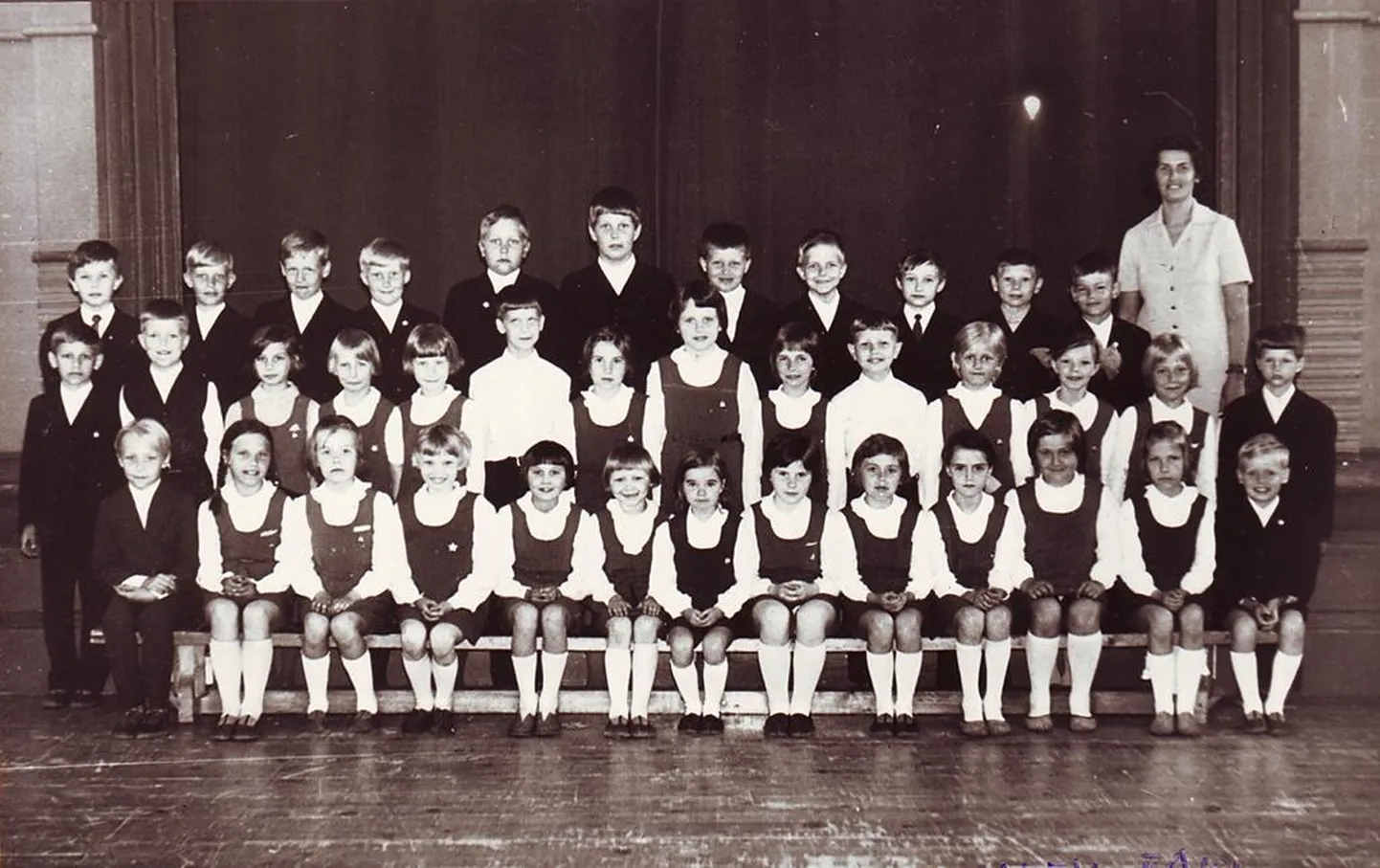 Pärnu V kaheksaklassilise kooli IIa klass koos klassijuhataja Laine Pärgiga 1975. aasta kevadel. Kõigil on seljas 1968. aastal kehtestatud pidulik koolivorm.