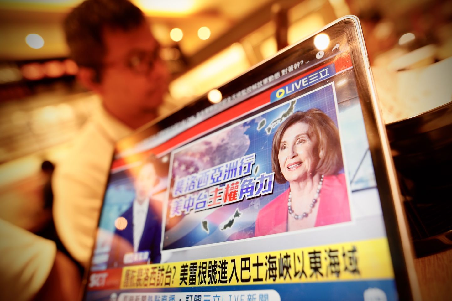 Житель смотрит новости об ожидаемом визите спикера Палаты представителей США Нэнси Пелоси в Тайбэй.
