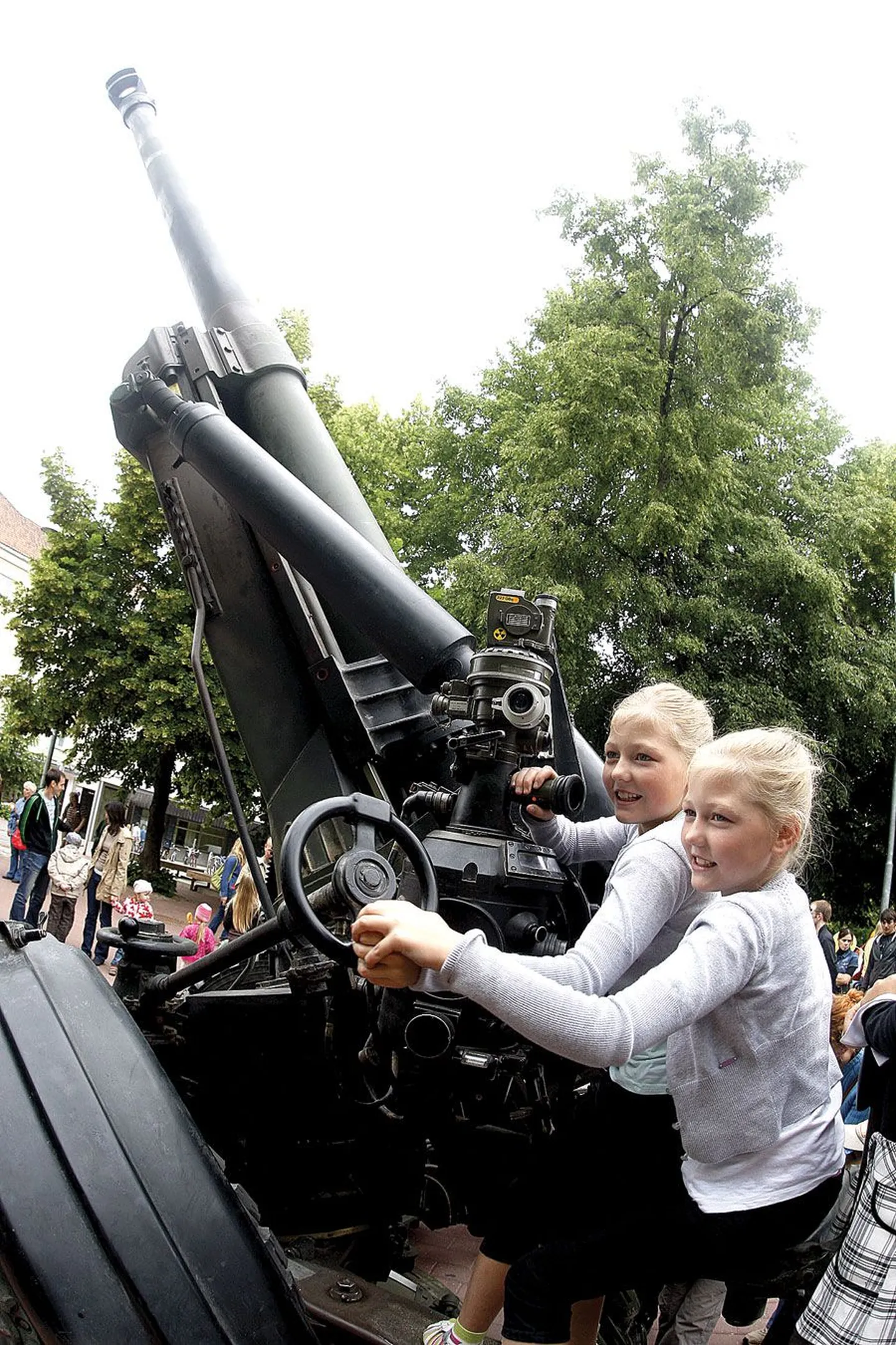 Maakaitsepäevaks Küüni tänavale ülespandud sõjatehnikanäituse ühe populaarseima vaatamisväärsuse, 155-millimeetrise haubitsa pildile mahutamisega oli fotograafil tükk tegu. Teiste hulgas katsetasid haubitsaga sihtimist Petserist paraadiks Tartusse sõitnud kaksikud Elisabeth ja Katharina Kõopuu.