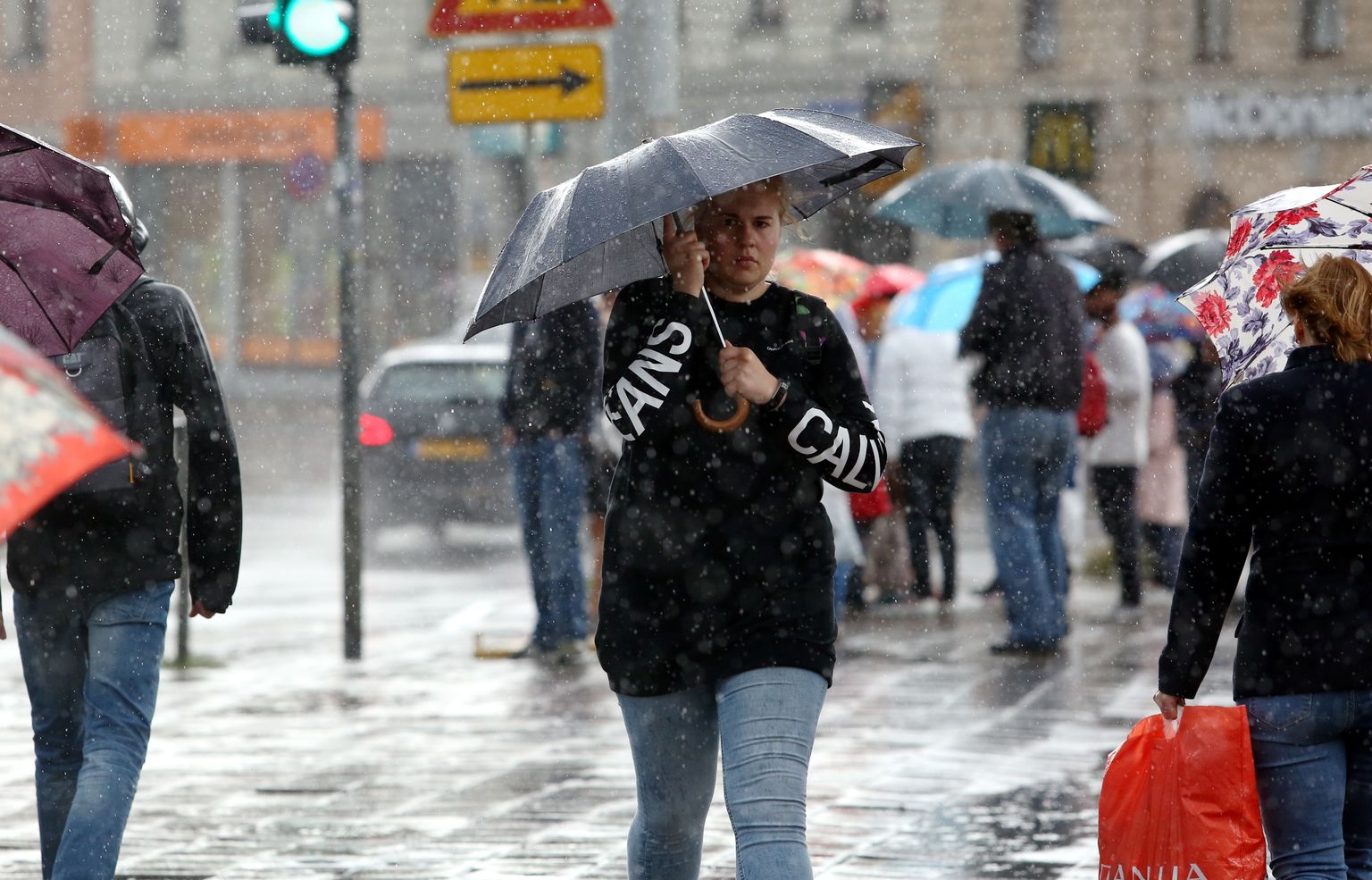 Cilvēki negaisa laikā Rīgā. Ilustratīvs attēls.
