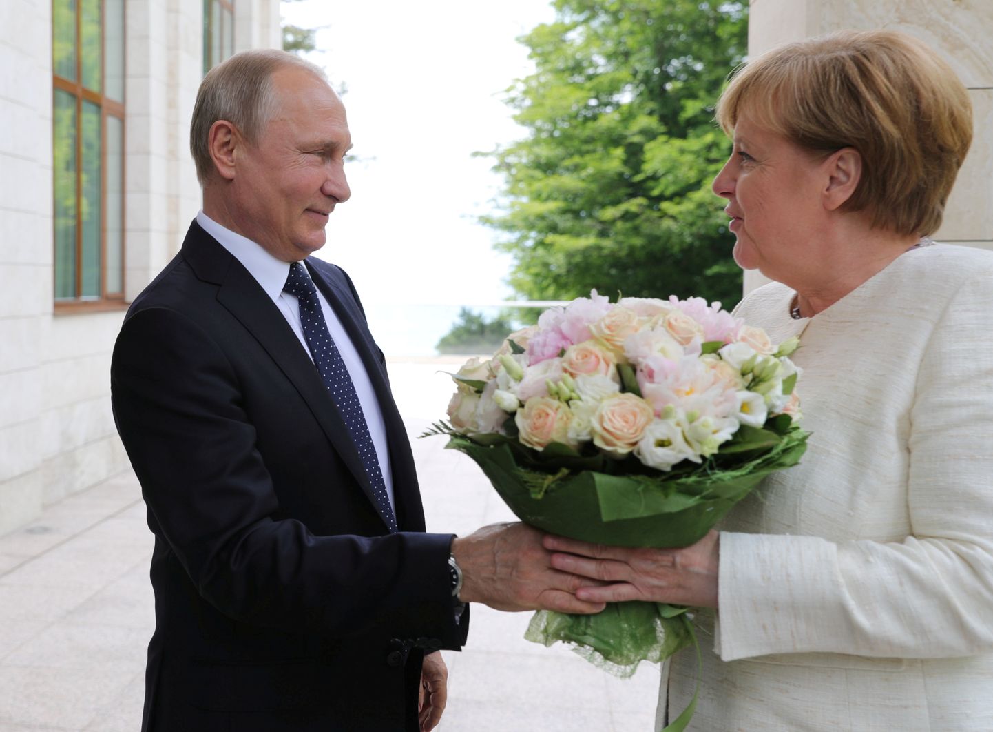 Владимир Путин дарит букет Ангеле Меркель.