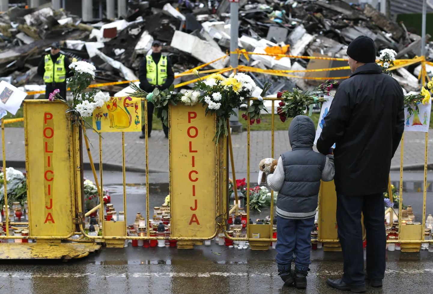 Люди приносят цветы и свечи к месту трагедии.