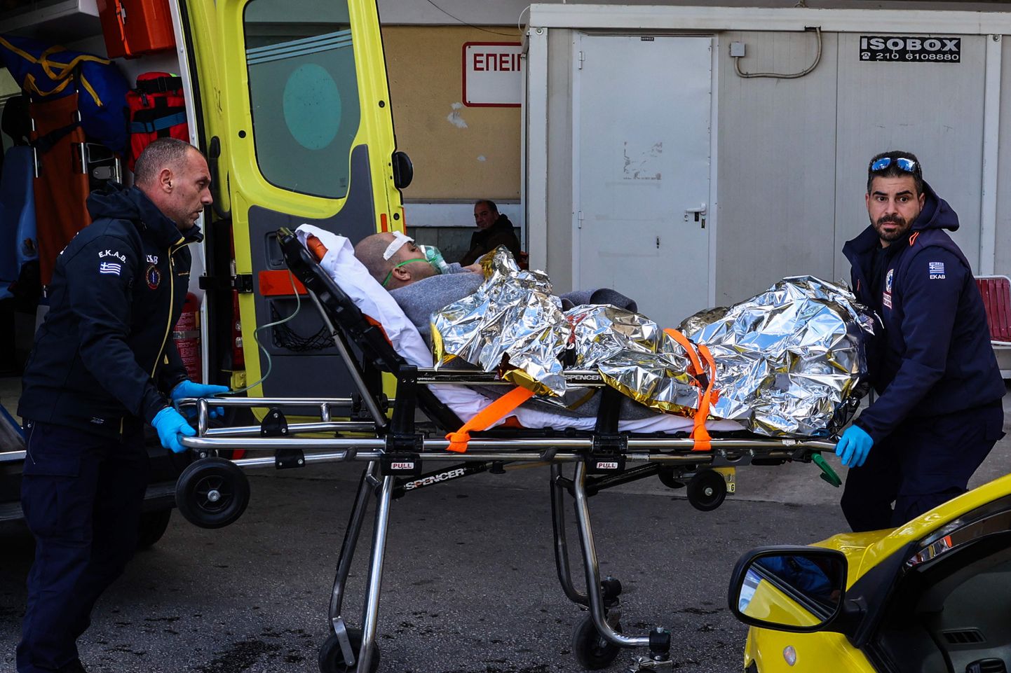Медицинские работники несут на носилках выжившего с грузового корабля, затонувшего у острова Лесбос.