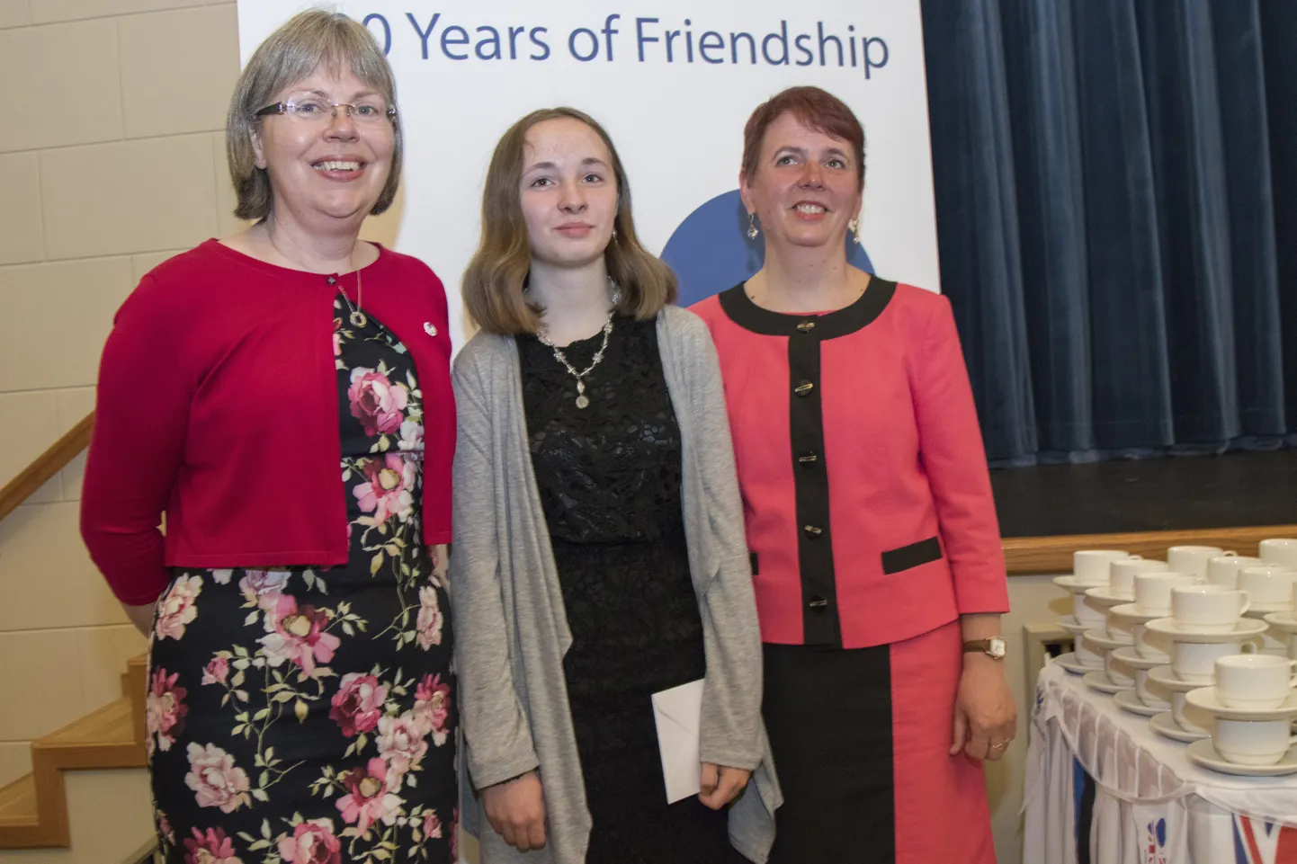 Seitsmenda klassi tüdruk Annabel Kukk sai eile Sakala keskuses teepeol kätte kutse kuninganna kübarapeole. Fotol on ta koos Briti suursaadiku Theresa Bubbeari ja ema Krista Kukega.