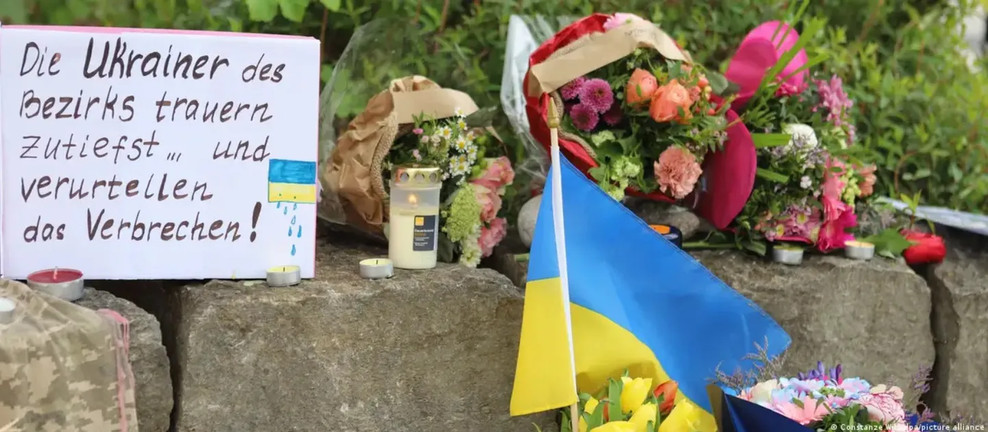 Украинцы и другие жители Мурнау несут свечи и цветы к месту убийства двух украинских военных, которые проходили реабилитацию в Баварии