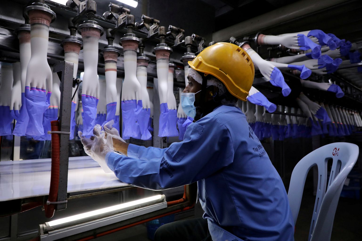 Töötaja kontrollib vastvalminud kinnaste kvaliteeti Top Glove'i tehases Shah Alamis, Malaisias (26.08.2020)