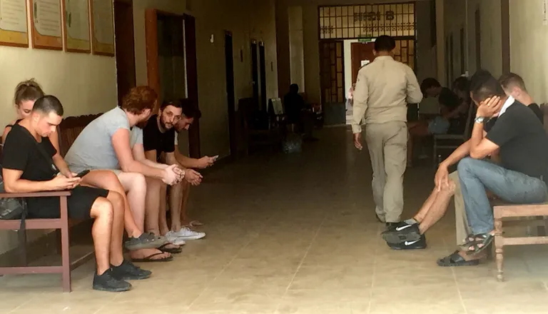 Arreteeritud turistid ootavad kohtu eesruumis istungit.