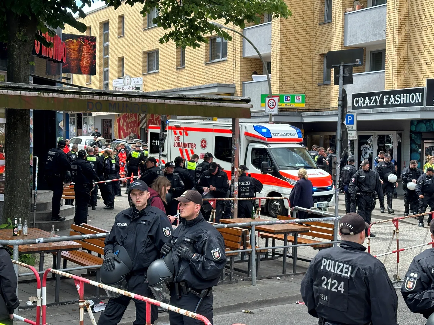 Полиция и скорая помощь в Гамбурге на месте, где 16 июня полиция выстрелила в мужчину, угрожавшего киркой и зажигательной смесью.