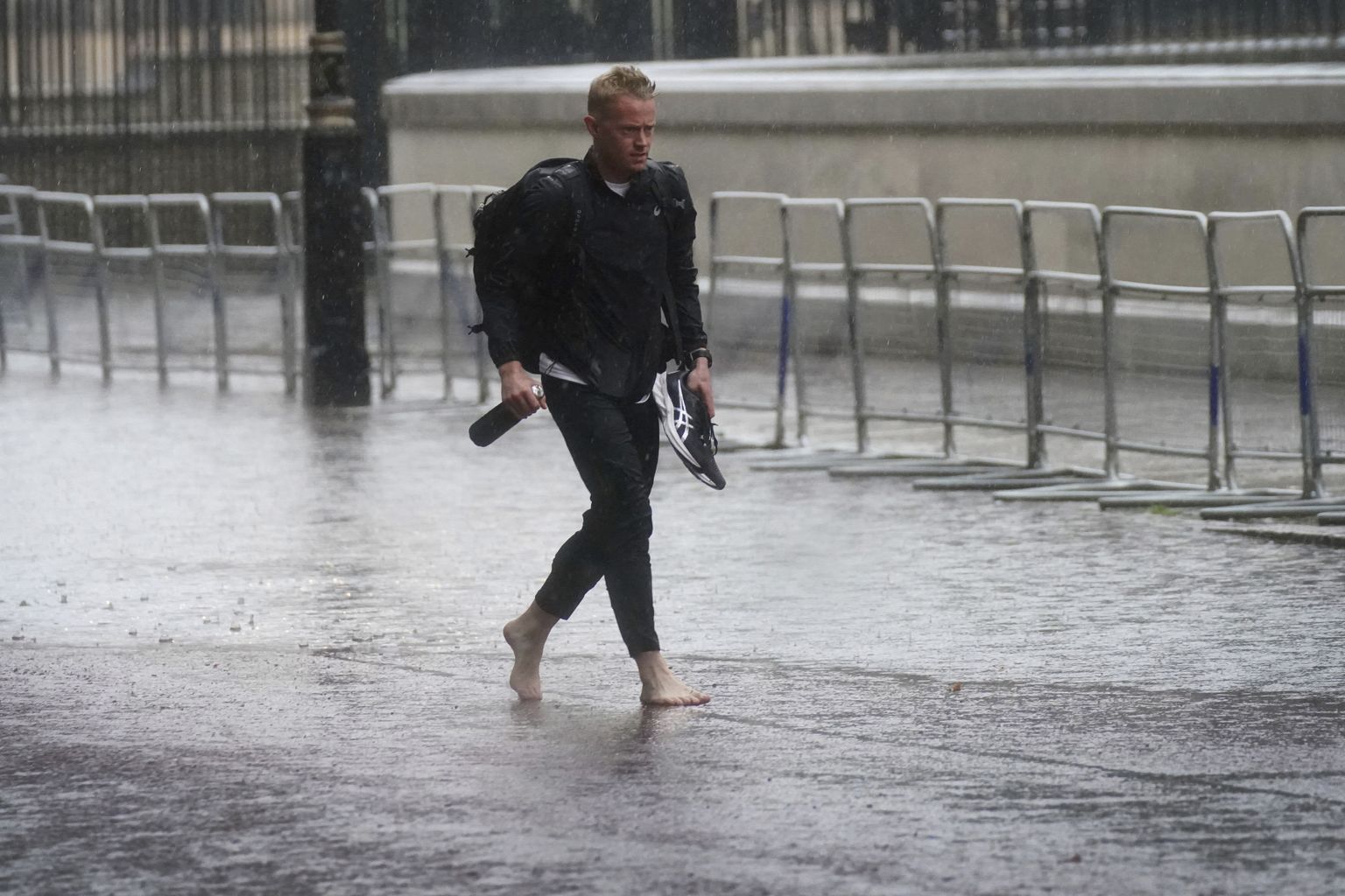 Mees jalutamas Suurbritannias Londonis Horse Guards Roadil paduvihmas paljajalu
