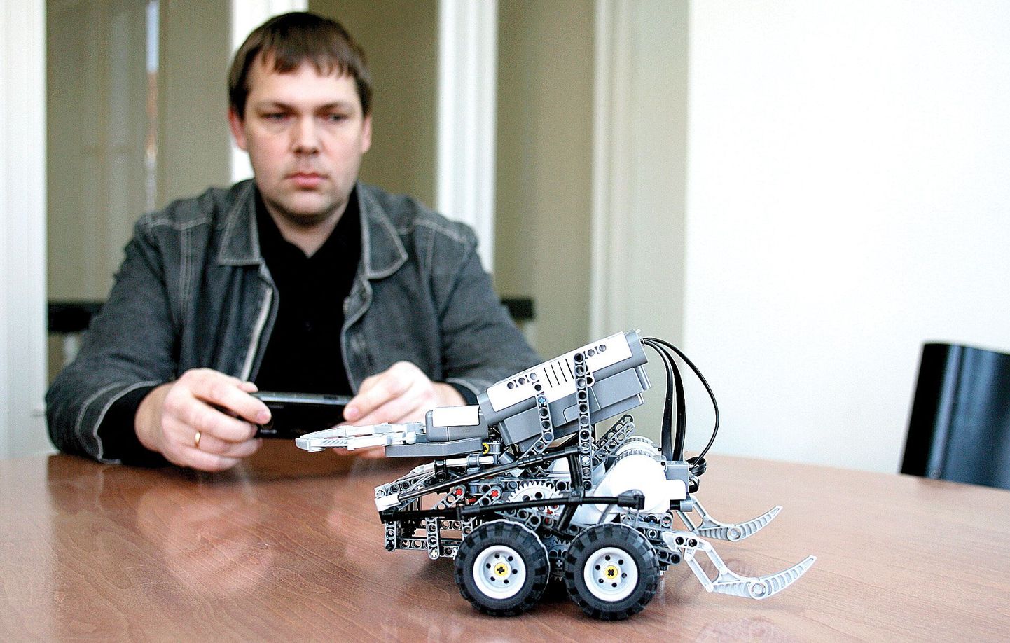 Montrolleri üks meeskonnaliige Asko Seeba näitab, kuidas nutitelefoniga legorobotit juhitakse. Nii nagu robotit siledal laual, võiks mobiiltelefon edaspidi kas või muruniidukit mööda koduõuesid ringi sõidutada.
