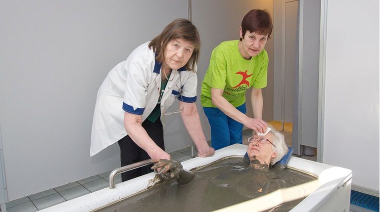 Helvi Koppel (vasakul) koos vannitaja Thea Mägiga patsiendi eest hoolitsemas ajal, kui hotellis Meris veel mudavanne sai võtta.