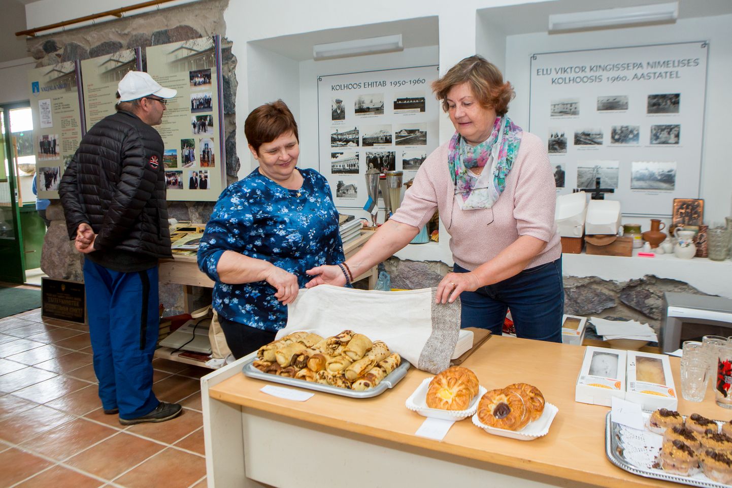SAIALE JA KOOGILE: Maie Rattas (vasakul) ja Kiira Pilviste pakkusid rahvale maitsvaid suupisteid. Näitusega tutvub Toomas Kupits.