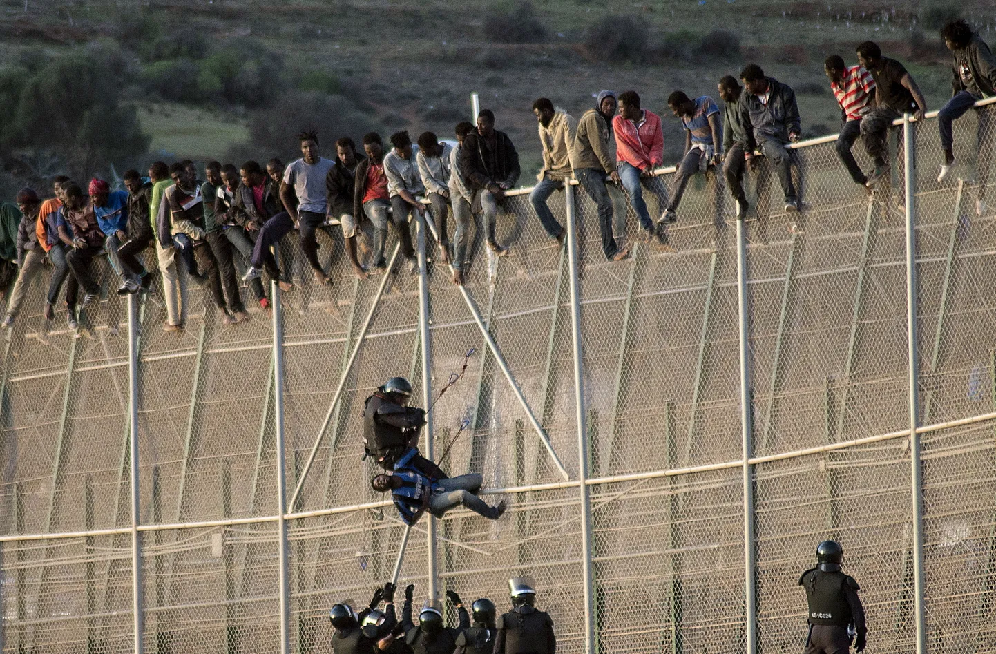 Migrants from Morocco climbing the border fence of the Spanish enclave of Ceuta.