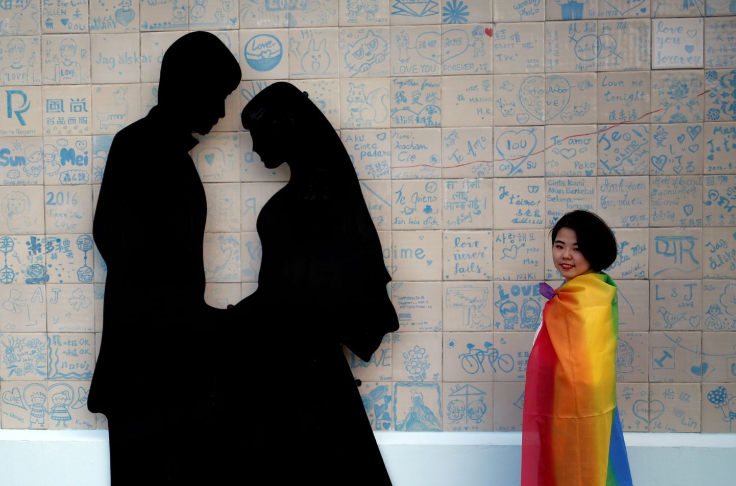 A participant poses next to a wedding studio during a lesbian, gay, bisexual and transgender (LGBT) pride parade to support same-sex marriage in Taipei, Taiwan, October 27, 2018. REUTERS/Tyrone Siu     TPX IMAGES OF THE DAY