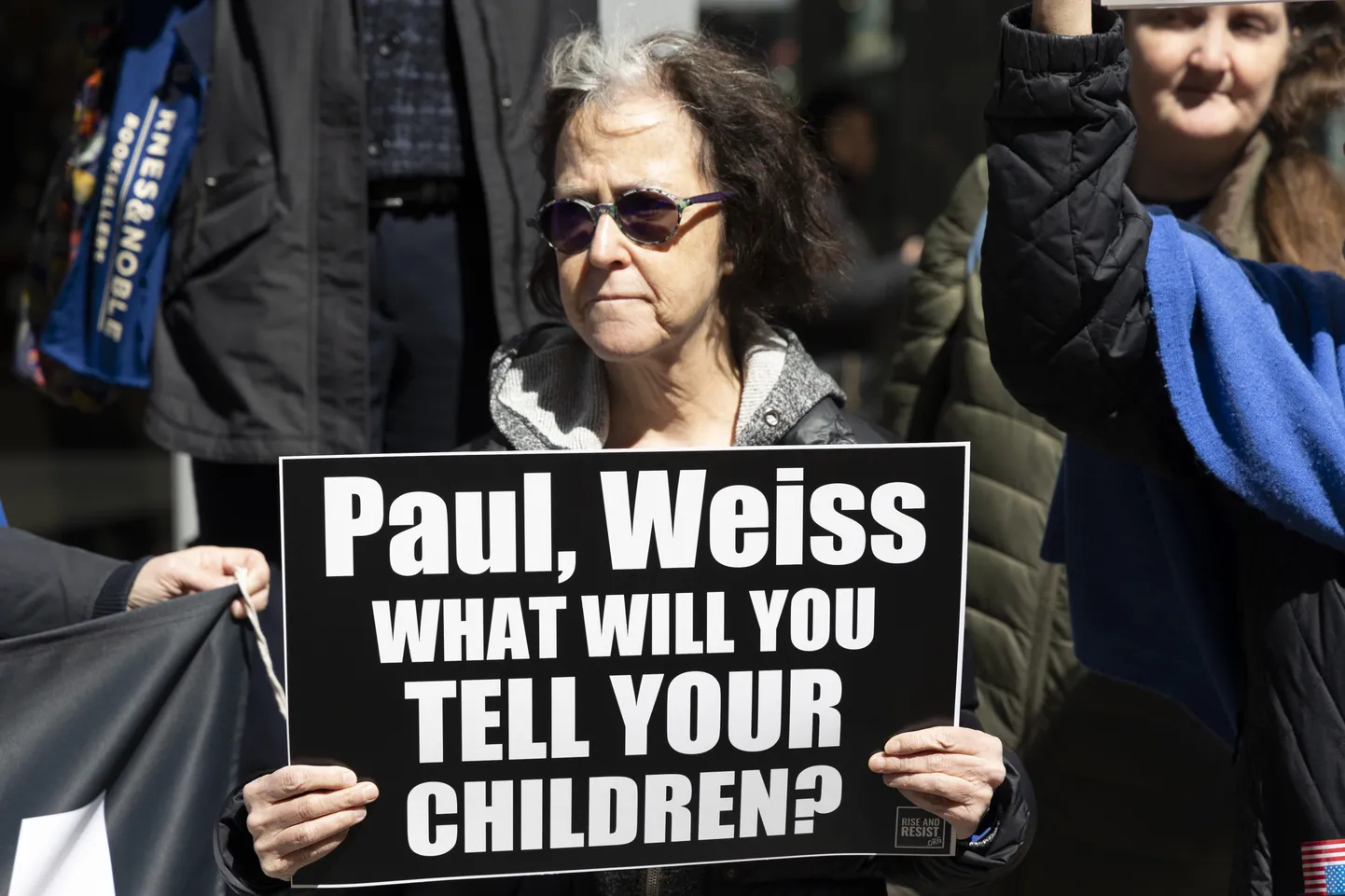 Protestiaktsioon Paul, Weiss büroo ees DEI-poliitikast loobumise ja Trumpi abistamise tõttu. Sildil: «Paul, Weiss, mida te oma lastele ütlete?».