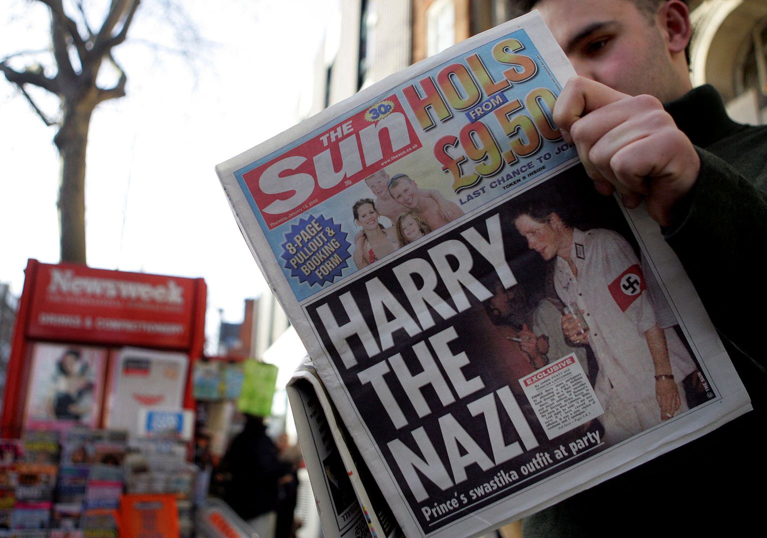 Mees lugemas 13. jaanuaril 2005 Londonis väljaannet The Sun, mille esikaanel on prints Harry natsikostüümis