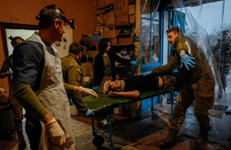 Медики 47-й бригады украинской армии доставляют в стабилизационный пункт в Донецкой области под Авдеевкой раненого бойца, чтобы оказать ему первую помощь.