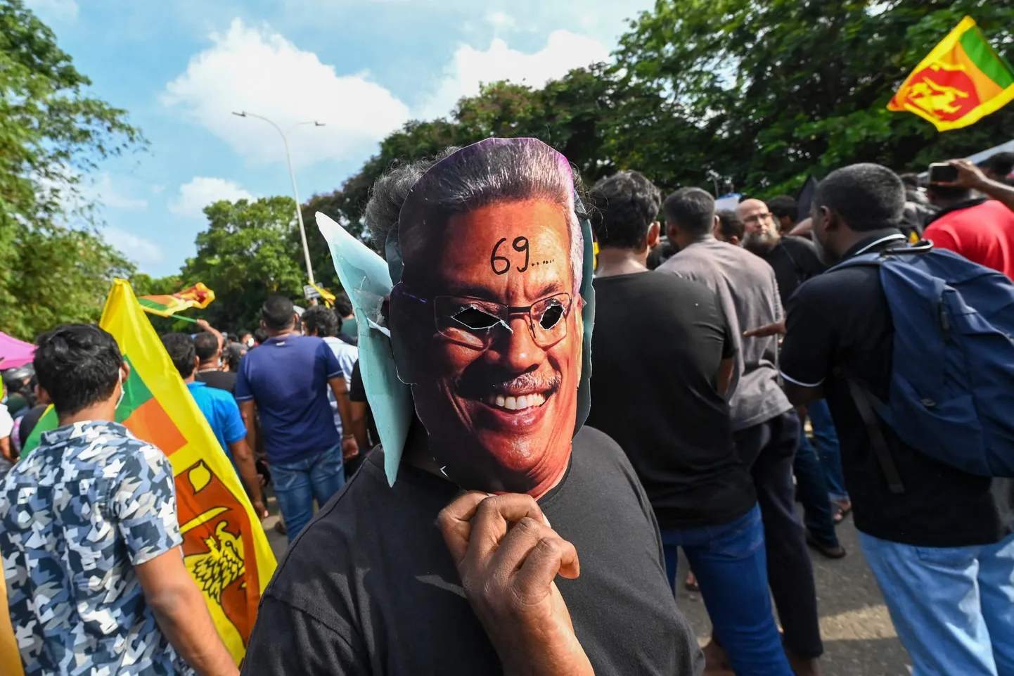 Meeleavaldaja mai alguses hoidmas näo ees Gotabaya Rajapaksa näoga maski.