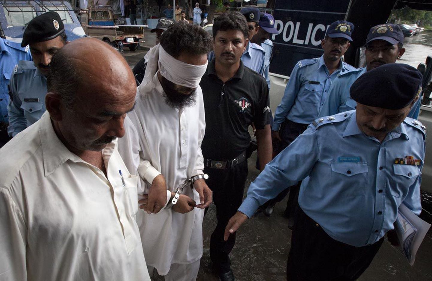 Tugevalt turvatud imaam Khalid Jadoon Chishti eile Islamabadis kohtusse minemas.
