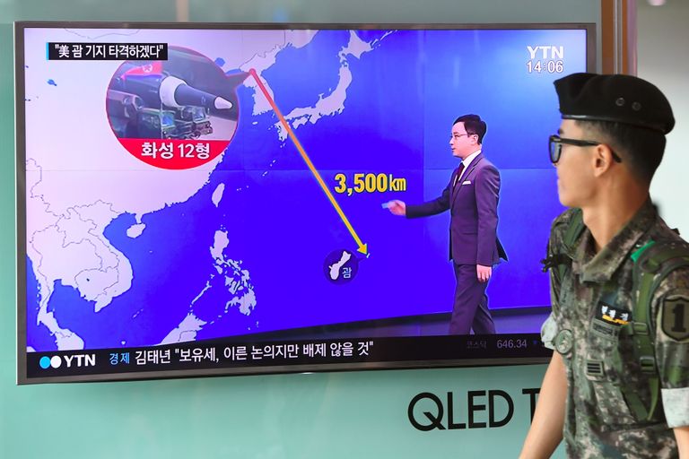 Lõuna-Korea sõdur möödumas Soulis raudteejaamas televiisoriekraanist, kus näidatakse vahemaad Põhja-Korea ja Ameerika Ühendriikidele kuuluva saare Guami vahel. / Scanpix