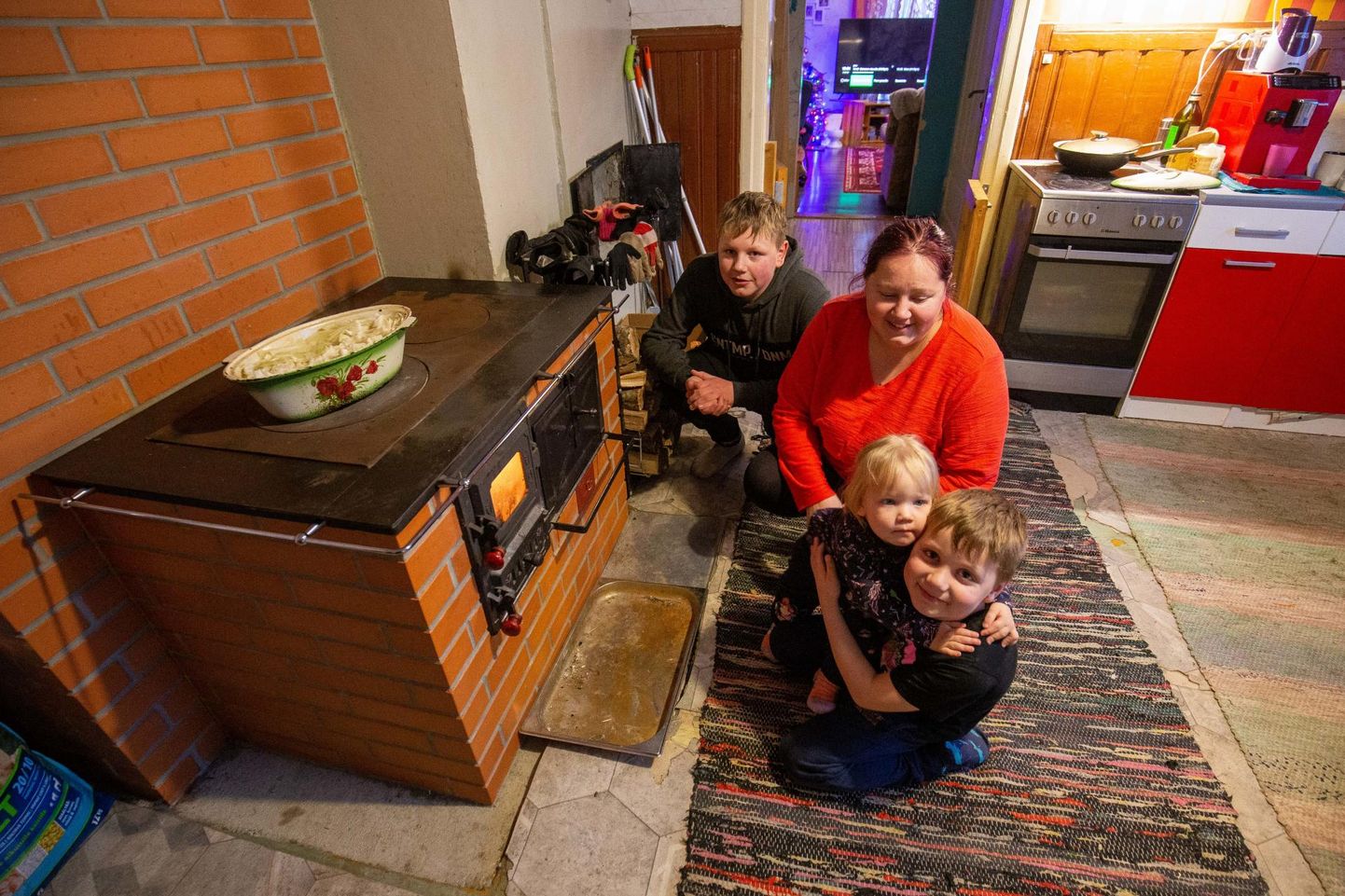 Marina Jõgiste ning tema lapsed Virgo (vasakult), Daniel ja Kerily tunnevad uuest pliidist suurt rõõmu, sest see kütab maja mõnusalt soojaks ja sellel podiseb alatihti maitsev toit.