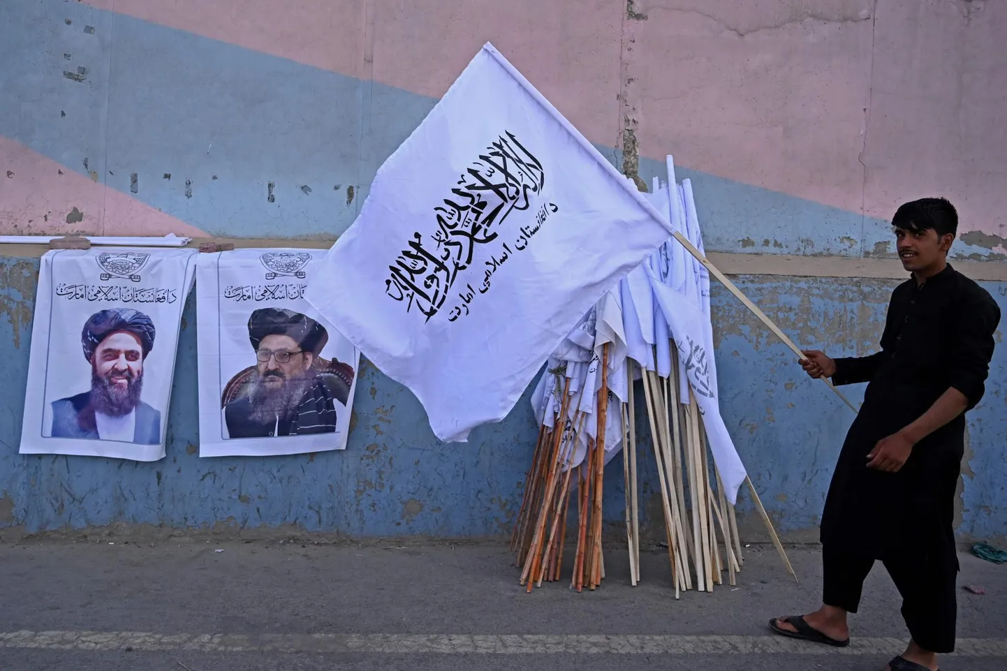 Tänavakaupmees Talibani lipu ja terrorirühmituse juhtide plakatitega.