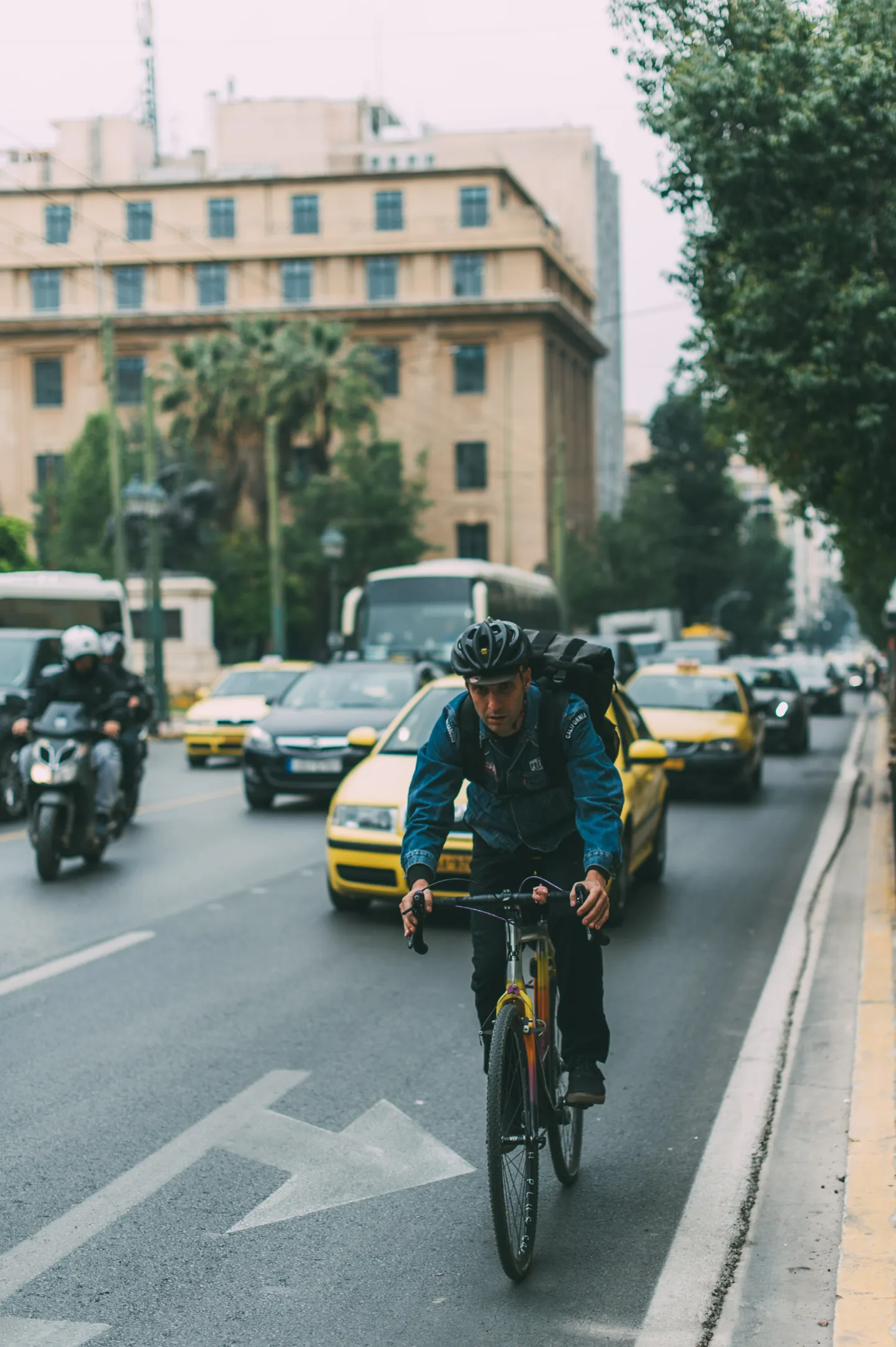 Velobraucējs pilsētas satiksmē starp automašīnām