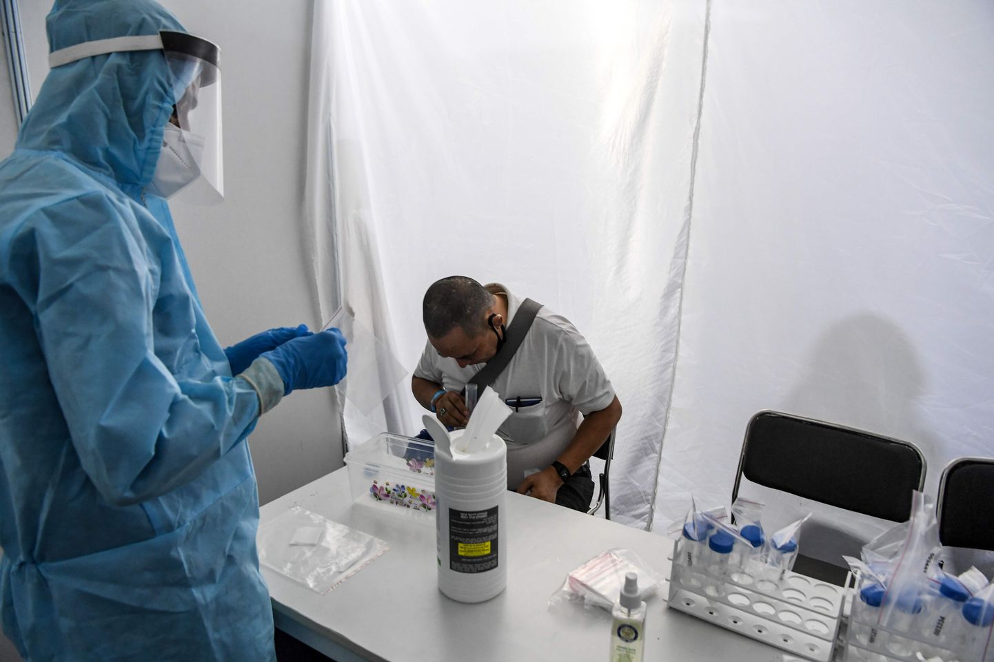 Kaitserõivastes tervishoiutöötaja võtab süljeproovi koroonaviiruse uuringu tarbeks Ram Manohar Lohia haiglas New Delhis, Indias, 31. juulil 2020.