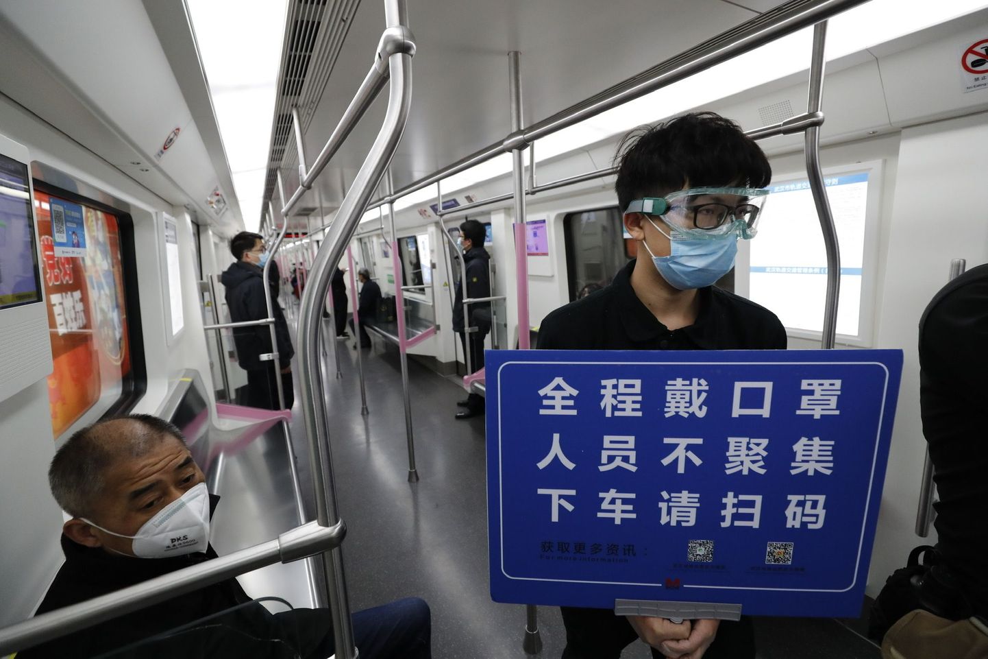 28.märts 2020, Wuhan. Hiinas on liikumispiirang läbi saanud. Ohutustööline palub reisijatel skaneerida QR-kood oma nime tuvastamiseks, lasta end kraadida ja kanda maske.