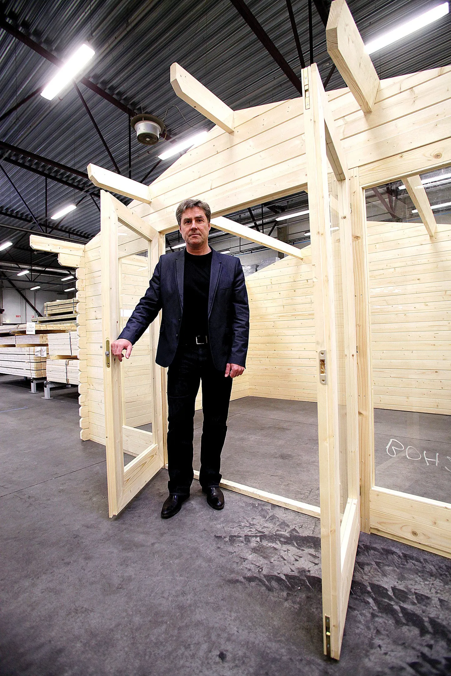 Kaido Maisvee seisab uues tootmishoones ühe Saksamaale tehtud näidismaja uksel.
