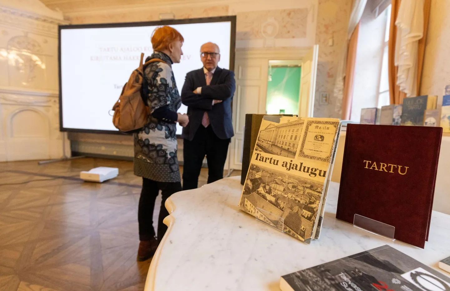 Tartu ajaloo uue koguteose kirjutama hakkamise päeval vestlesid linnamuuseumi saalis peatoimetaja Enn Küng ja kaastoimetaja Lea Leppik, nende juures laual oli püsti sätitud seni ilmunud kolm koguteost, aga ka muid meie linna ajaloo teemalisi trükiseid.