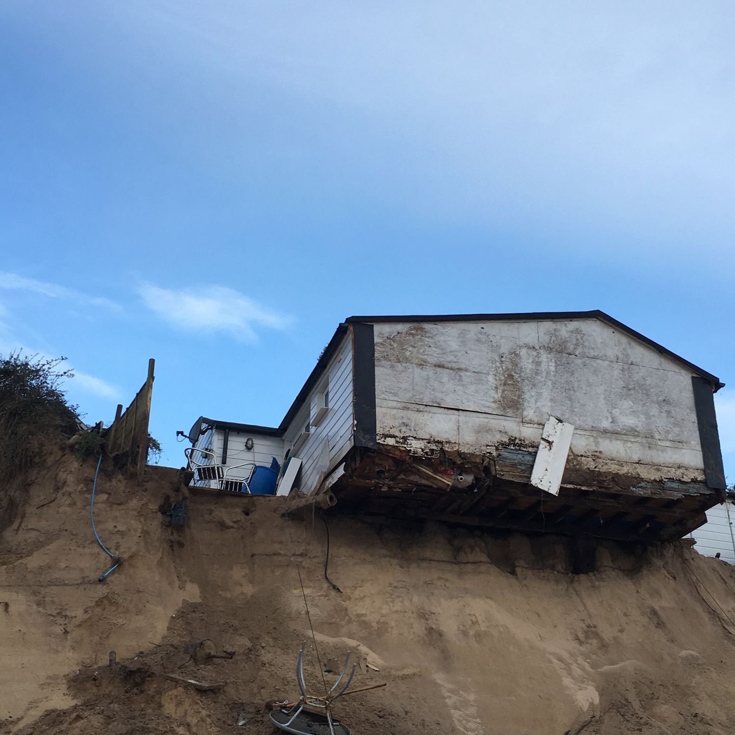 Lance Martin's property in Hemsby, Norfolk just after the storms that ruined the other houses on the cliff edge. Lance's home was the only one to survive the Beast from the East storms on a crumbling cliff but has been told to stop carrying out work to protect his home. See SWNS Cambridge copy SWCAcliff:A resident whose cliff-top property was the only one to survive the Beast from the East storms on a crumbling cliff has been told to stop carrying out work to protect his home. Lance Martin, 60, had been using a mechanical digger to transfer concrete blocks and piling up sand to protect his home ahead of winter.This comes after a number of houses perched on a cliff edge were evacuated and demolished due to the aftermath from the Beast from the East, in March this year.