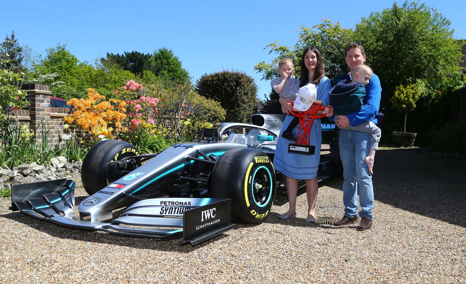 Harry Shaw poseerib isa Jamesi süles koos ema Charlotte'i ja õe Georgiaga. Kõrval Lewis Hamiltoni vormel 1 masina koopia ning Hispaania GP võidukarikas.