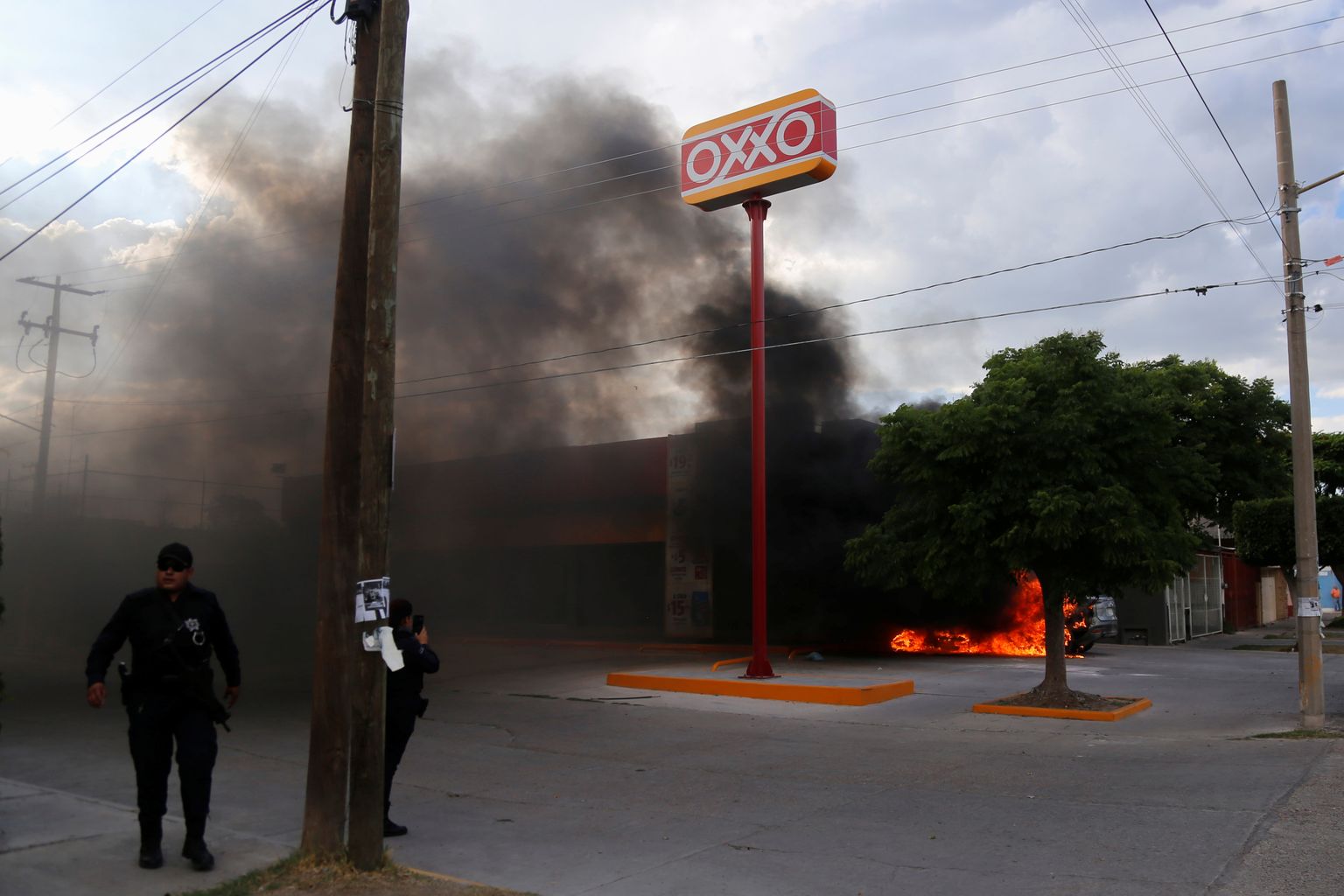 Politseinikud Guanajuatos põleva auto juures.