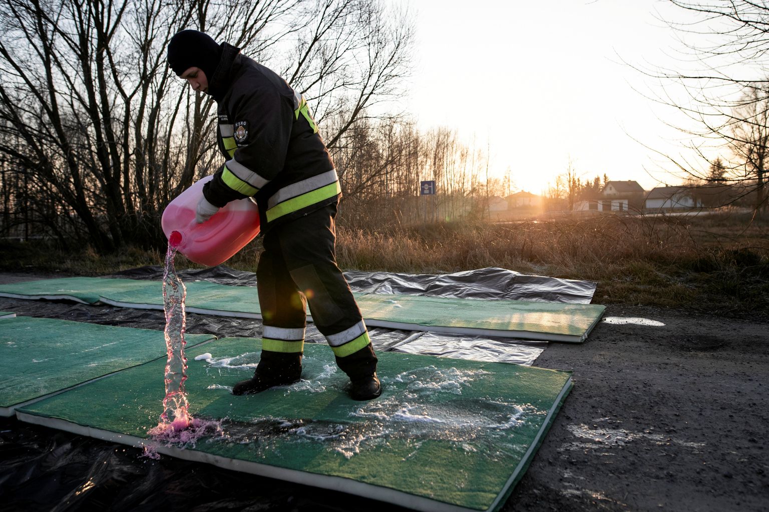 Poola tuletõrjuja valamas 3. jaanuaril desinfitseerijat teele pärast seda, kui lähedalasuvast Stary Uścimówist leiti linnugrippi.
