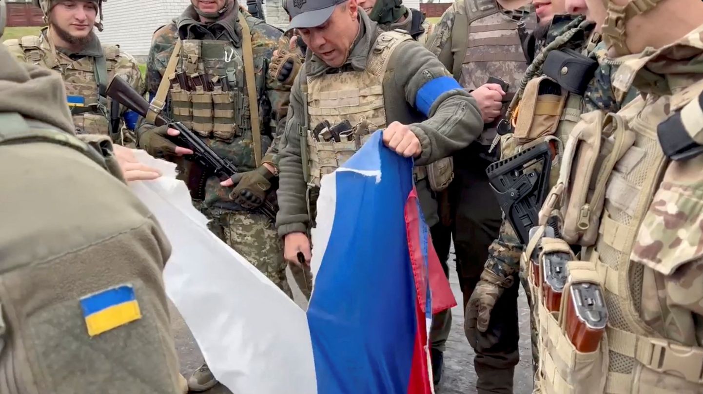 Ukrainas karavīri saplēš Krievijas karogu.