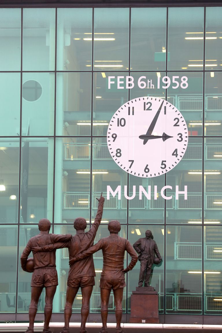 Aeg Manchester Unitedi kodustaadionil Old Traffordil peatus igaveseks lennukatastroofi toimumise hetkel. Esiplaanil klubi kolme suurmängija ehk George Besti, Denis Law ja Bobby Charltoni ühine kuju, taamal kella all Matt Busby kuju.