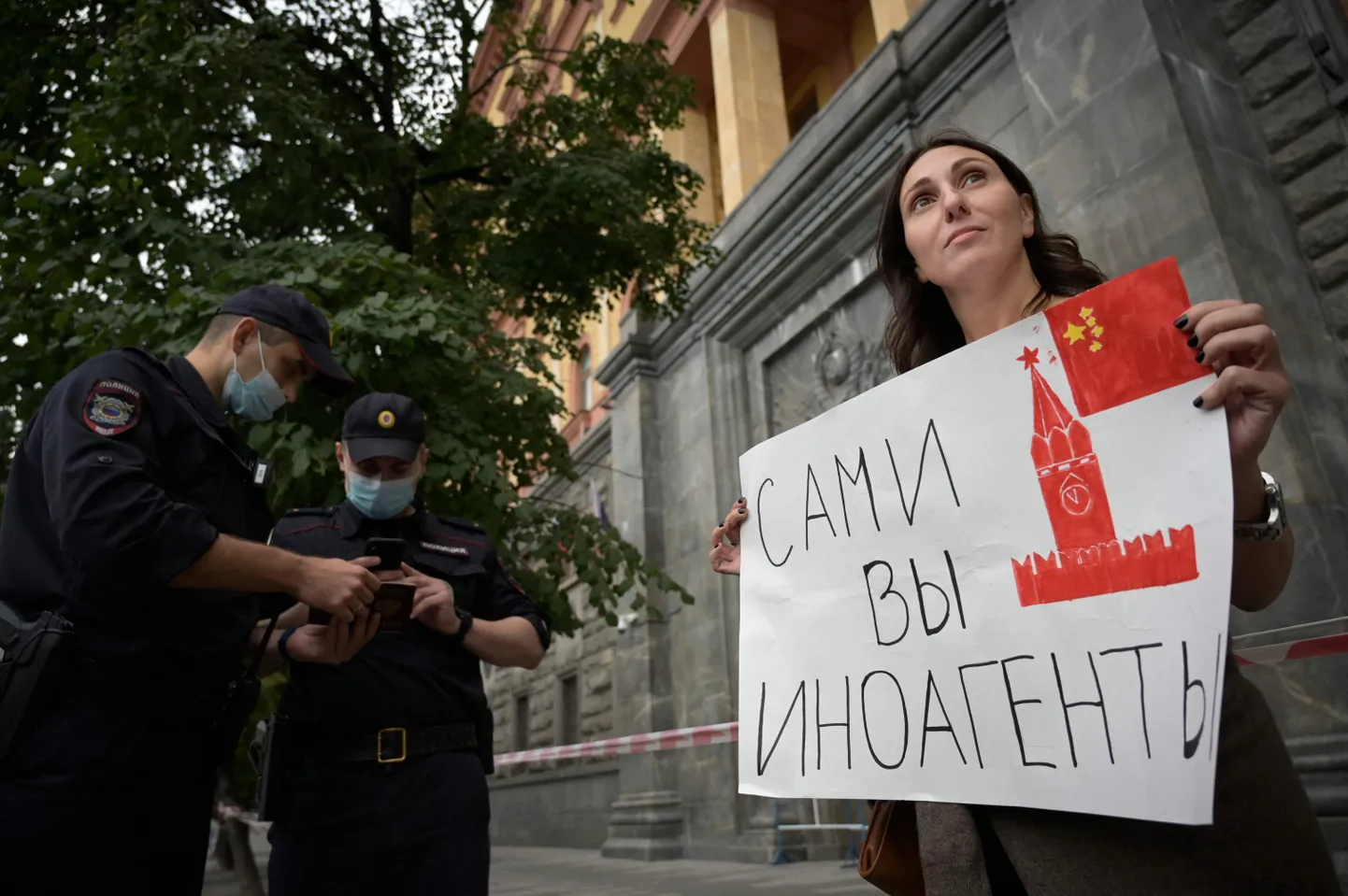 Журналист Ирина Баблоян держит плакат «Сами вы иностранные агенты», где у кремлевской башни китайский флаг. Одиночный пикет (по формальным законам РФ не требует разрешения властей) в поддержку журналистов, внесенных в список «иностранных агентов». Москва, Лубянка, центральный офис ФСБ, 21 августа 2021 года.