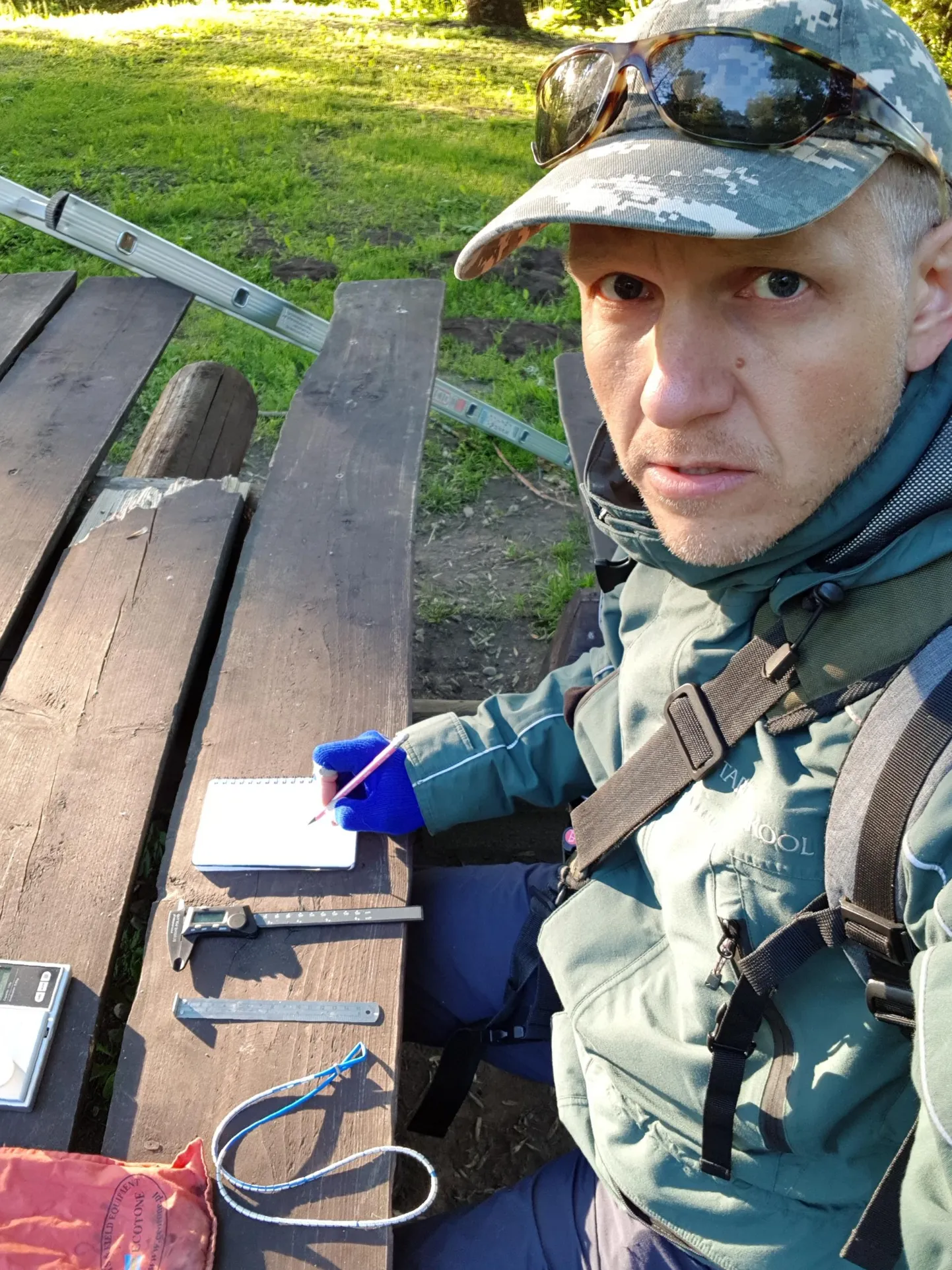 Niisugused välitöötingimused on puhas luksus, tavaliselt peab tagumiku ikka maha toetama. Laual Marko Mägi ees on näha tavavarustus lindude mõõtmiseks: nihik, joonlaud, elektrooniline kaal ja välimärkmik.