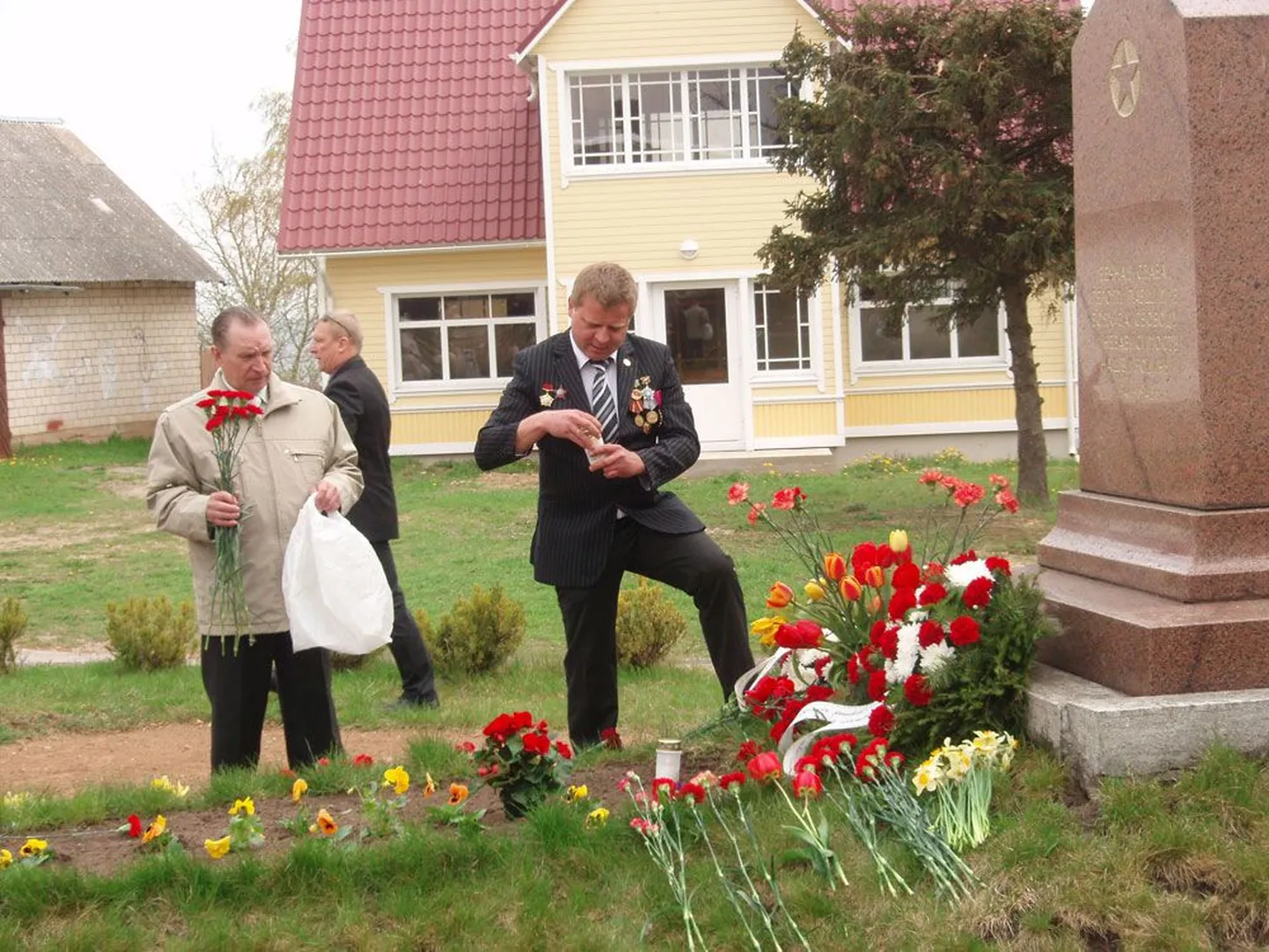 Viktor Nukka (pildil paremalt) kandis tänavu 9. mail, nn Suure Isamaasõja lõpu päeval armeepõlvest pärinevaid aumärke ning viis Kallaste mälestusmärgi juurde nelke. Samas viibisid ka volikogu esimees Fjodor Plešankov ja linnapea Igor Goidin-Karlov (tagaplaanil).