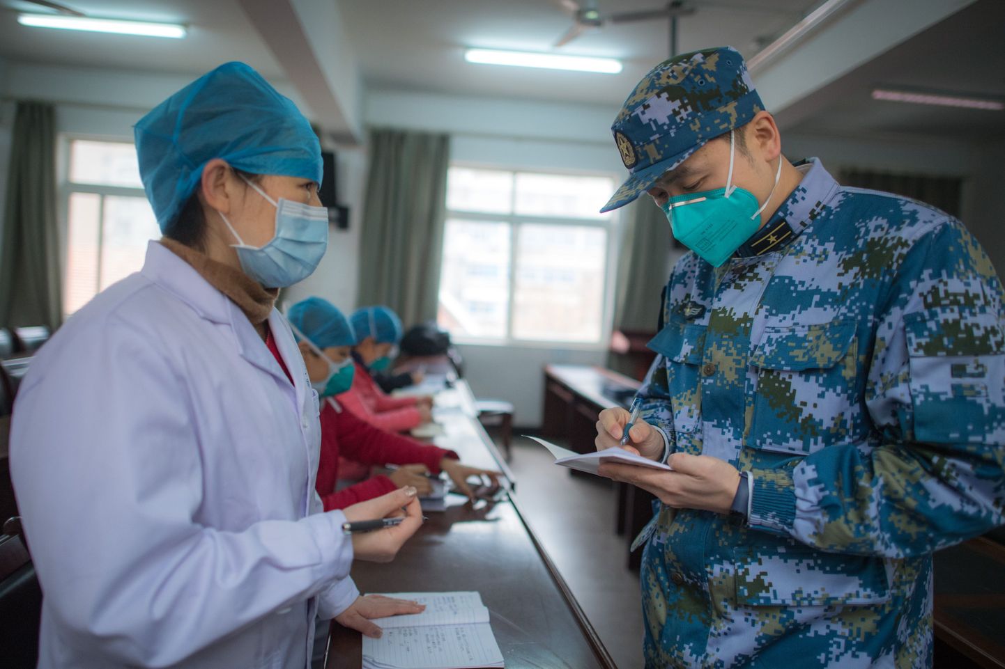 Sõjaväehaigla töötaja arutamas olukorda Wuhani Hankou haigla arstiga.